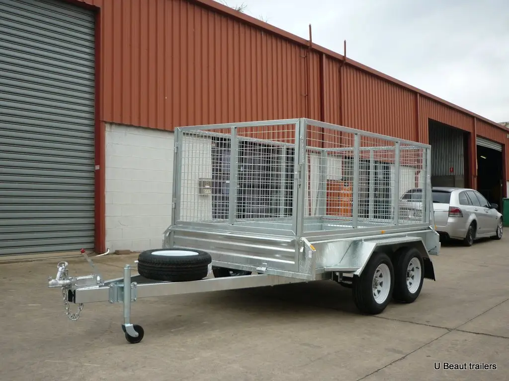 Example dual-axle box trailer with a mesh cage and two wheels visible on one side.